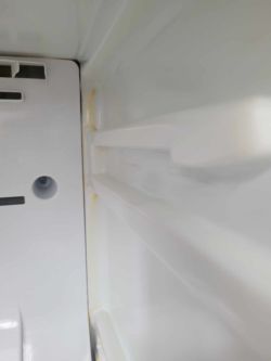 Żółte zacieki w tylnej części lodówki Samsung.