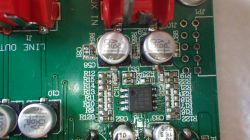 Nahaufnahme einer grünen Leiterplatte mit Kondensatoren, Widerständen und einem IC-Chip.