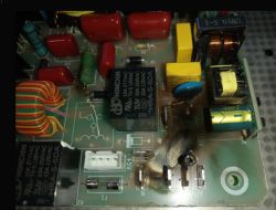 Uszkodzona płytka PCB z przypalonym miejscem wokół złącza i komponentami elektronicznymi