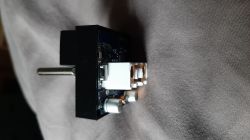 Circuit board with mounted switch and capacitors.