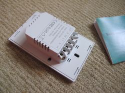Cozylife DS-1211AN Wall Switch A Cozylife DS-1211AN three-key touch wall switch lying on a beige carpet next to a user manual.