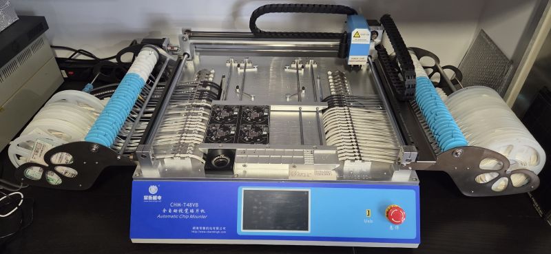 Automatyczna maszyna Pick and Place Charmhigh CHM-T48VB z zamontowanymi podajnikami i panelami PCB.