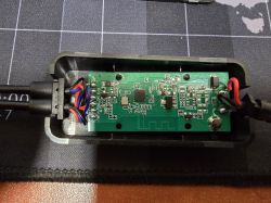 PCB with electronic components and colored wires inside a black plastic housing