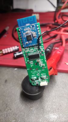Close-up of a green PCB with a blue electronic module mounted on it.