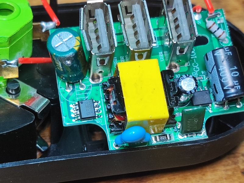 Wnętrze przedłużacza antyprzepięciowego z widocznymi komponentami elektronicznymi.