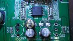 Nahaufnahme einer Leiterplatte mit mehreren Elektrolytkondensatoren und einem integrierten Schaltkreis.