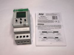 Zegar PCZ-526.4 i ulotka informacyjna leżące na białym tle