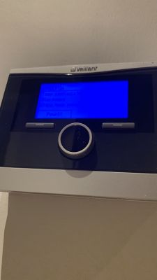 Sterownik kotła Vaillant z niebieskim ekranem i pokrętłem.