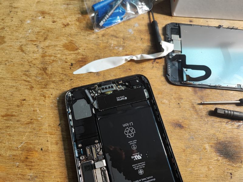 iPhone Battery Replacement Interior of a disassembled iPhone with a battery being replaced
