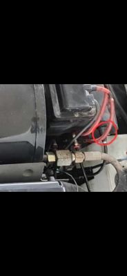 Część mechaniczna z przewodami i metalowym złączem, obok czerwonego zaznaczenia.