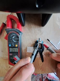 Osoba używająca miernika do pomiaru elektrycznego na komponentach.