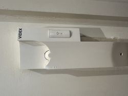 Part of a Videx intercom mounted on the wall.