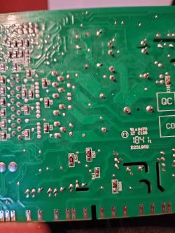 Zbliżenie na zieloną płytkę drukowaną z widocznymi ścieżkami i elementami elektronicznymi.