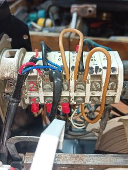 Zbliżenie przełącznika/łącznika z przewodami i mostkami; czerwone oznaczenia „1” i „2” na obudowie