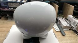 Smart LED Lamp on a Desk White, smart lamp with a rounded shape on a desk surrounded by boxes and cables.