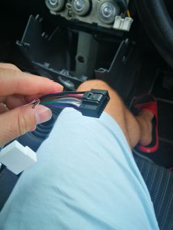 Osoba trzymająca adapter do montażu radia w samochodzie.