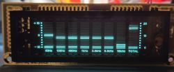 Turquoise-lit VFD display showing an audio spectrum analyzer with side level scales
