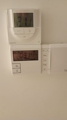 Termostat na ścianie pokazujący temperaturę 21,1 stopni Celsjusza oraz programator z wyświetlonym czasem 0:31.