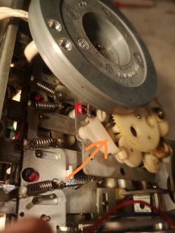 Zbliżenie na mechanizm zębatek z zaznaczoną częścią strzałką