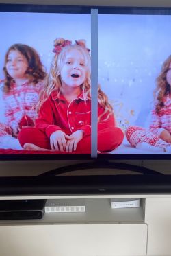 Telewizor z pionowym paskiem na ekranie, scena z dziecięcymi piżamami.