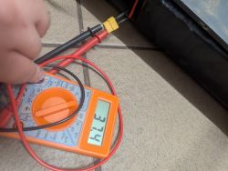 Multimetr wskazujący napięcie 37.4V podczas pomiaru hulajnogi elektrycznej.