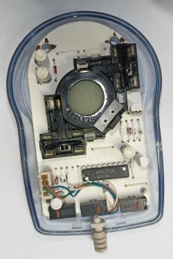 Interior of an old model computer mouse with disassembled plastic casing.