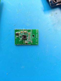 Printed circuit board of the SDV-002 V1.2 electronic module on a blue background.