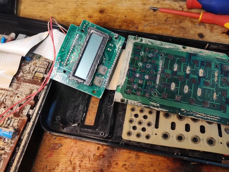 Wnętrze telefonu stacjonarnego Cyfral C 928 T/P z lat 90., z widoczną płytką drukowaną, wyświetlaczem LCD i klawiaturą membranową.
