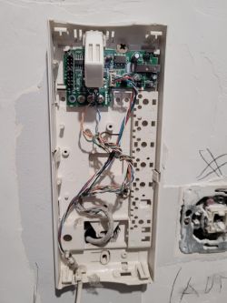 Instalacja unifonu z widoczną płytką drukowaną i kablami w bloku mieszkalnym.